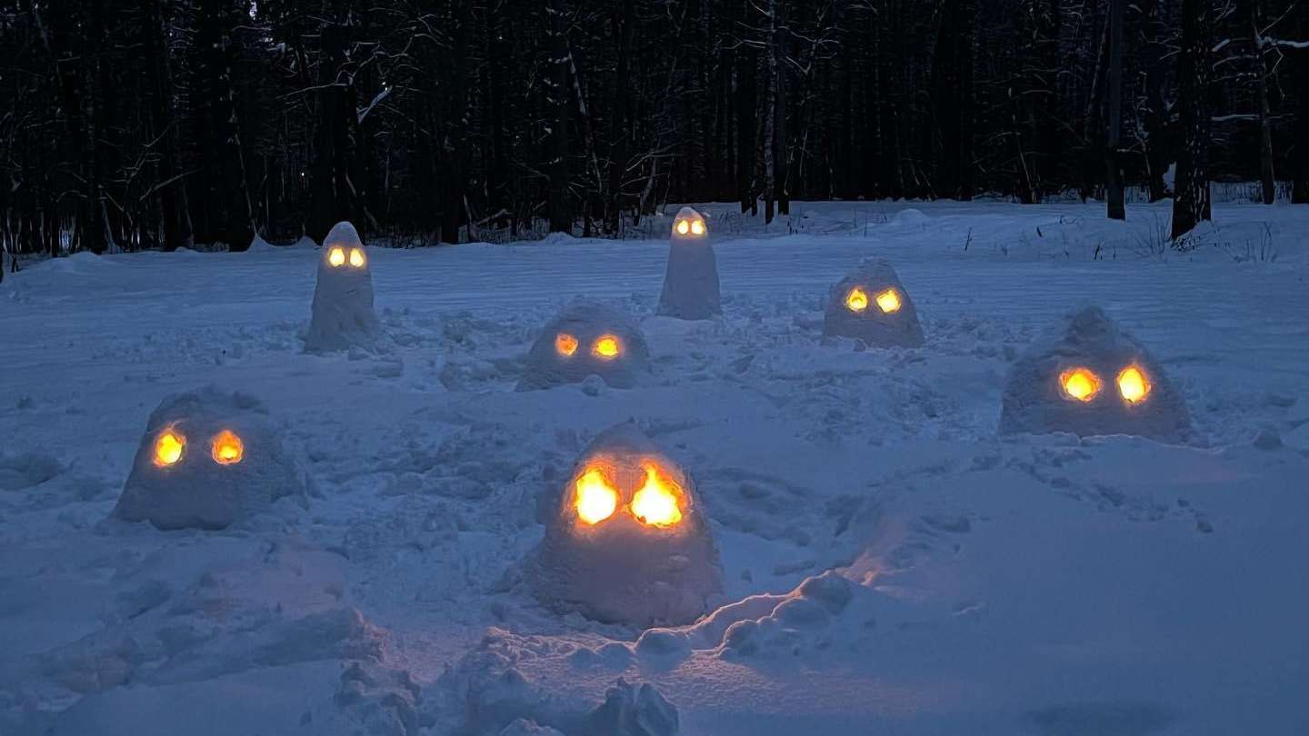 Snow sculptures glowing in a dark winter landscape