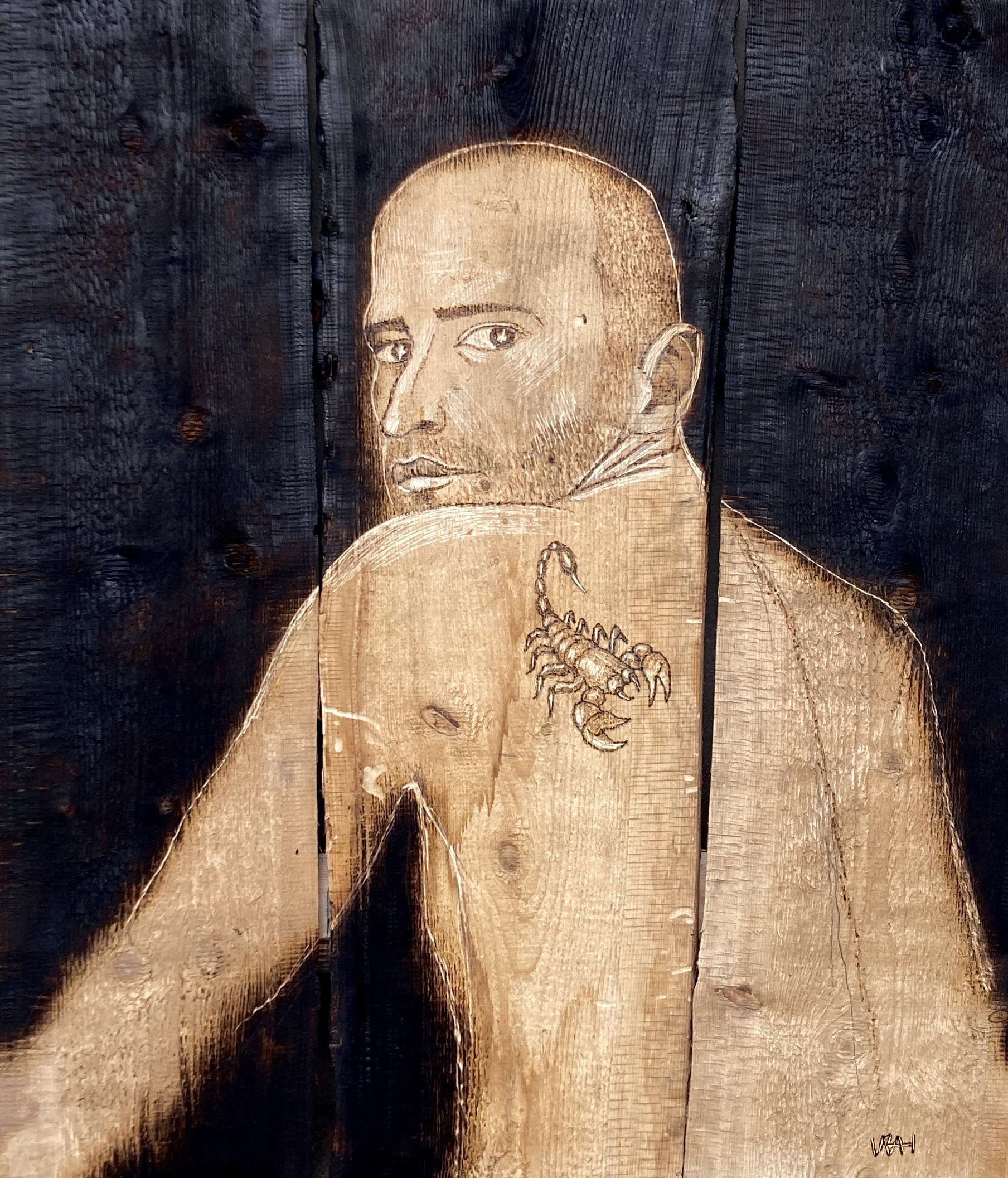Self-portrait carved into a burnt wooden board